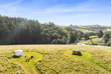 Aerial of the non electric grass pitches with views towards the lake