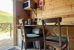 Microwave, kettle, fridge, table and chairs in the Carrock Fox shepherd's hut Microwave, kettle, fridge, table and chairs in the Carrock Fox shepherd's hut