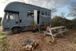 Converted horsebox with an outdoor fire pit and picnic bench