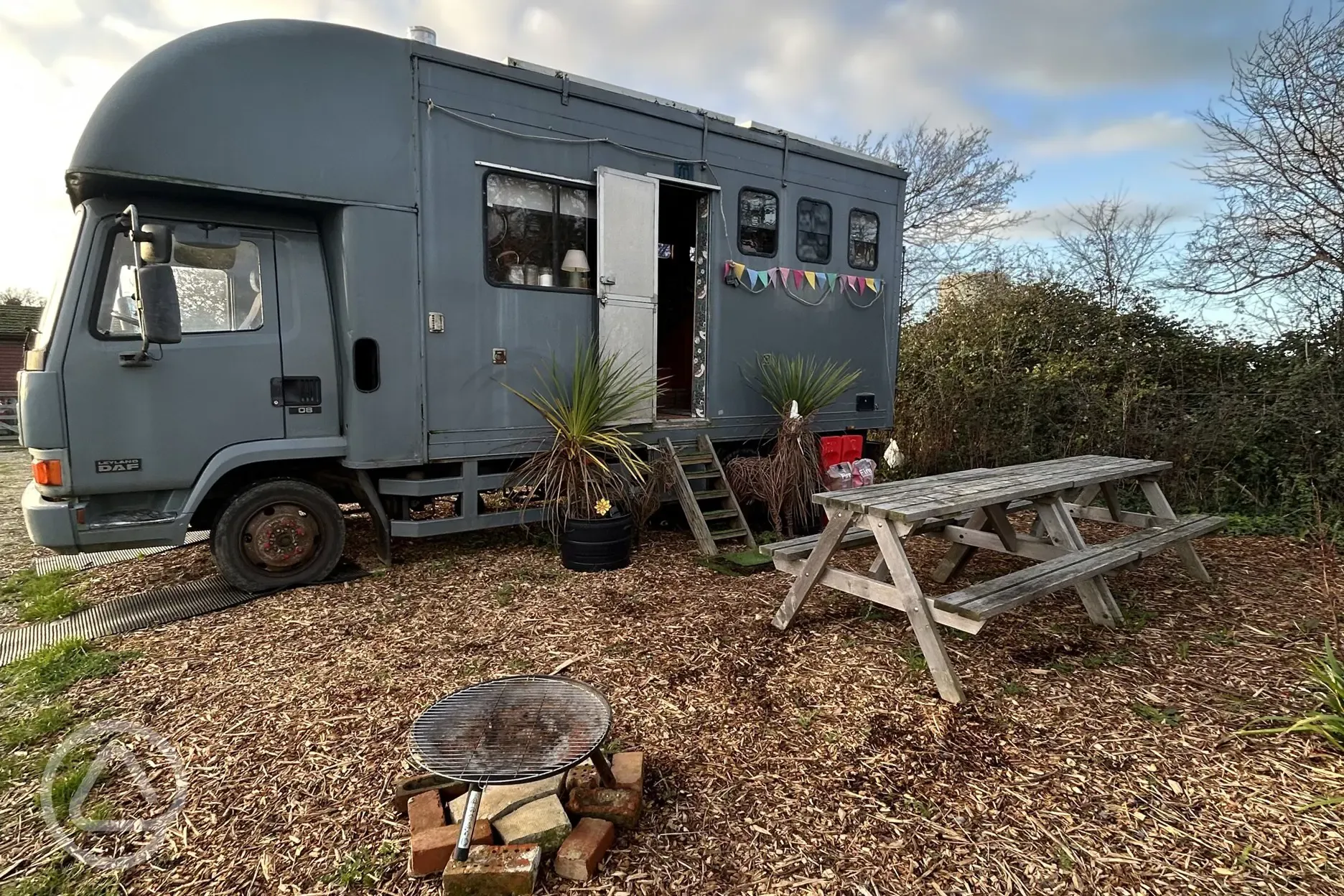 Converted horsebox with an outdoor fire pit and picnic bench