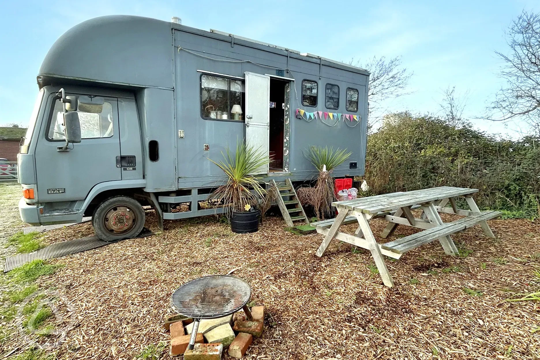 Converted horsebox with an outdoor fire pit and picnic bench