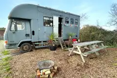 Converted horsebox with an outdoor fire pit and picnic bench