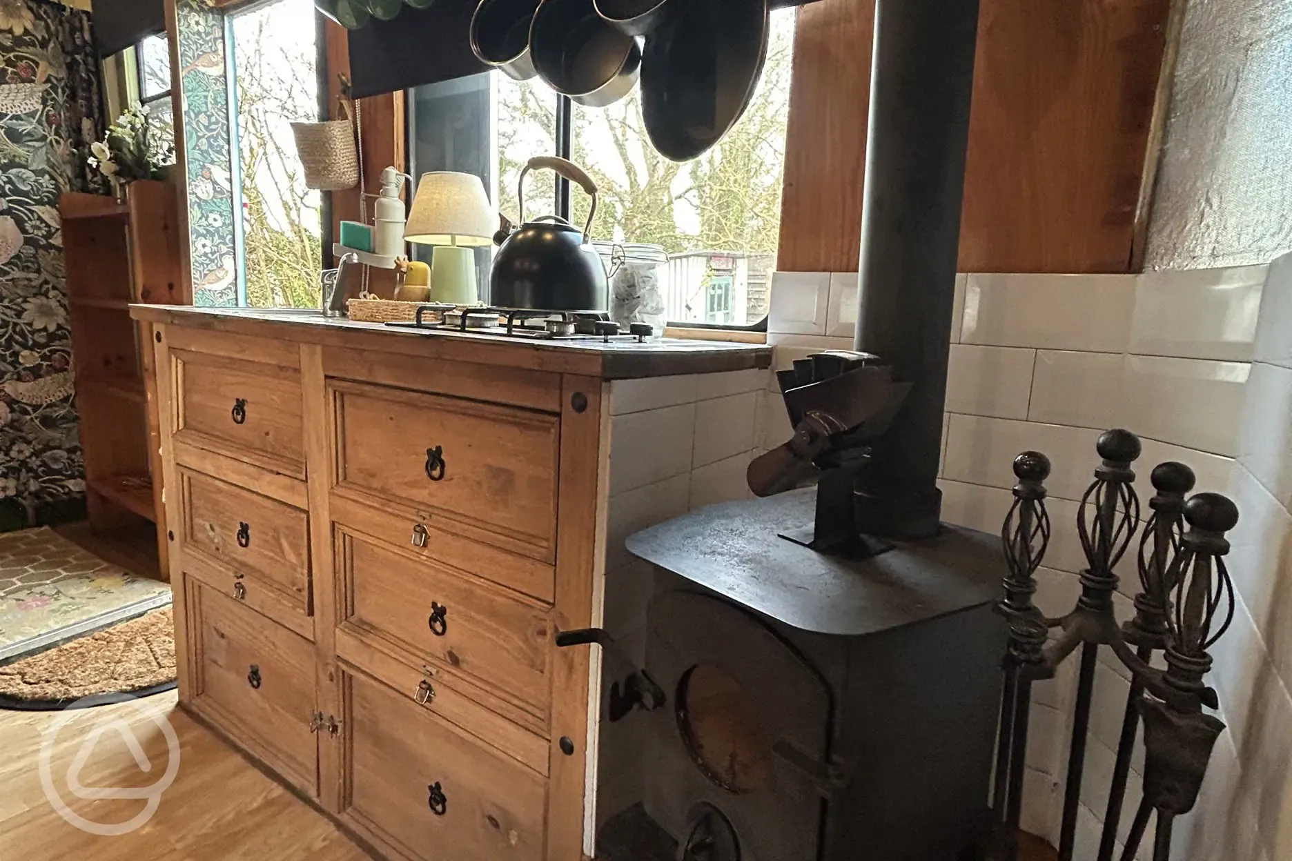 Converted horsebox living area with sofa seating and a log burner