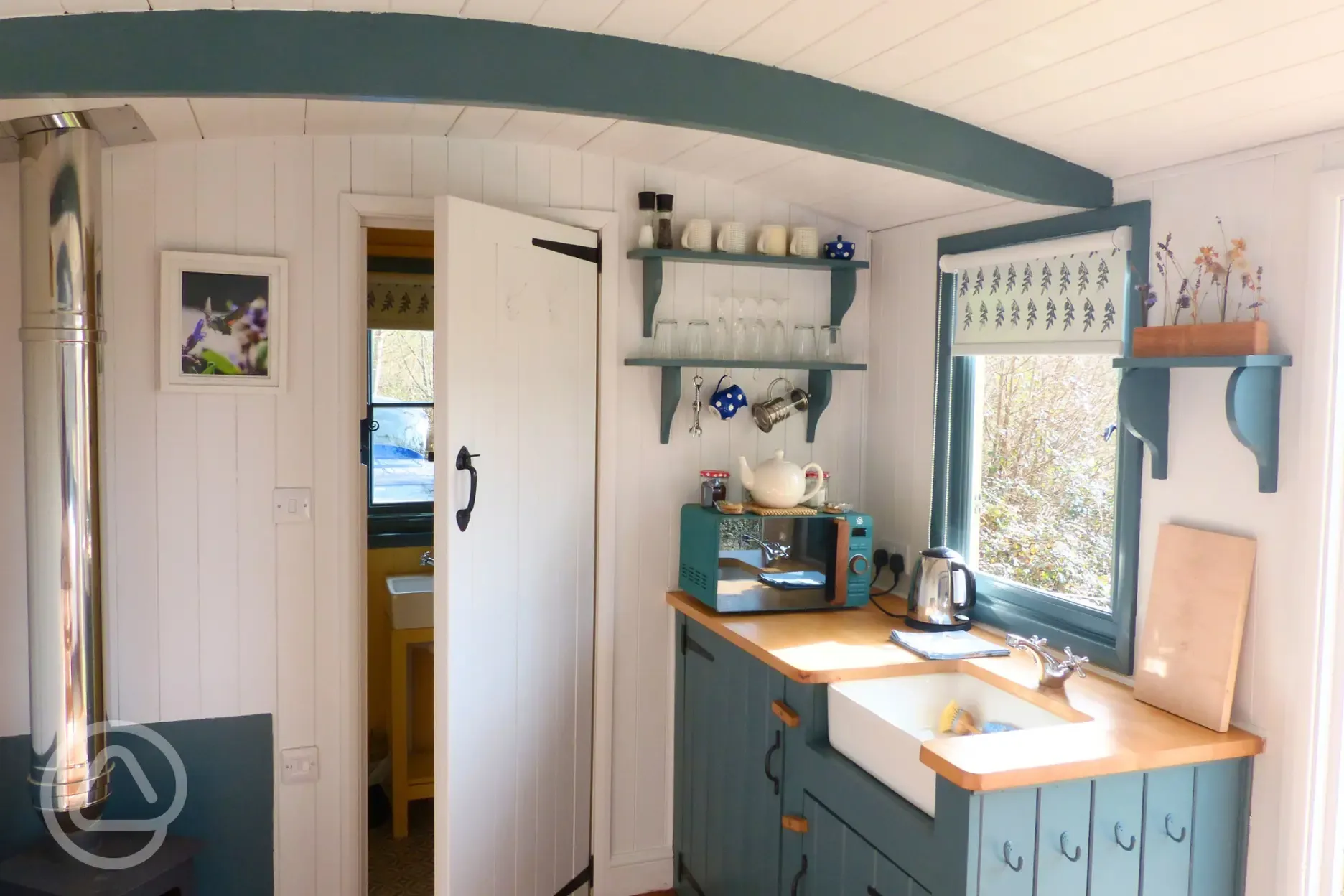 Oak shepherd's hut kitchen with a sink, fridge, microwave and kettle