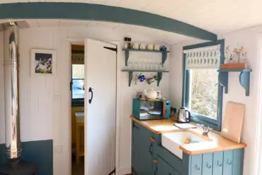 Oak shepherd's hut kitchen with a sink, fridge, microwave and kettle