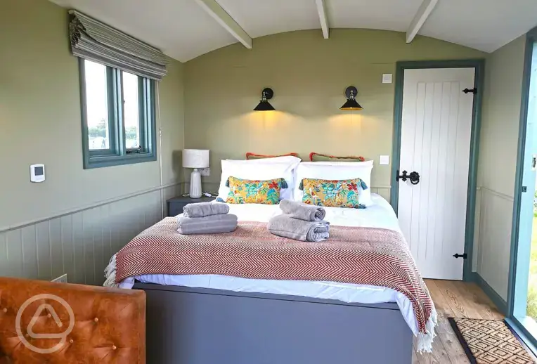 Shepherd hut interior with a king size bed, sleeping two adults and a child