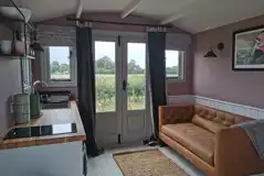 Shepherd's hut interior with sofa and fully equipped kitchen