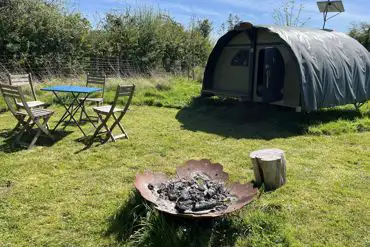 Landpod with a fire pit and seating area at Sindles Farm