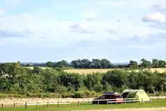Tent on an electric grass pitch with space for a parked car
