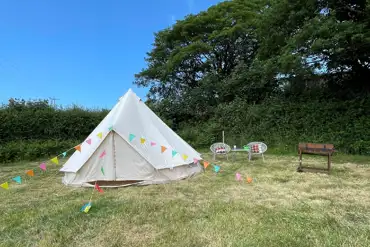 Outside the bell tent including seating and BBQ