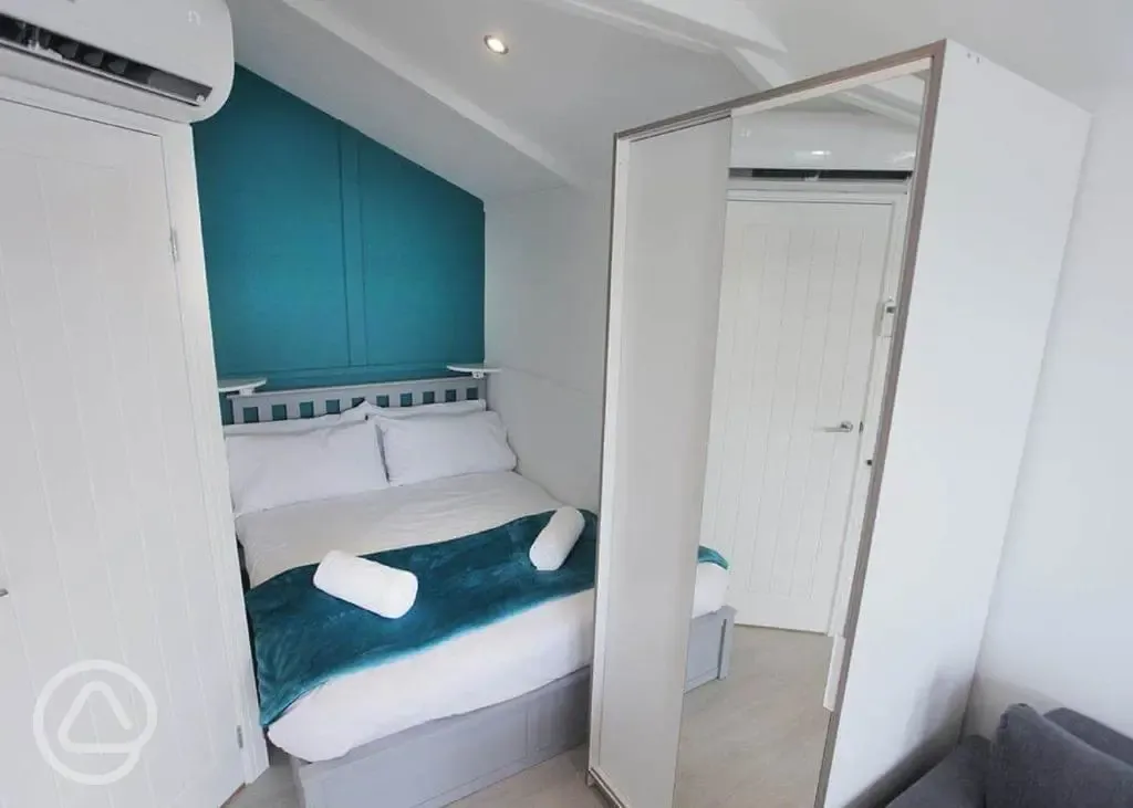 Marine ensuite glamping lodge bedroom with double bed and wardrobe