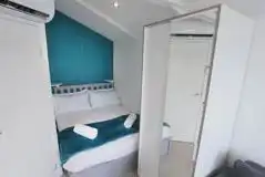 Marine ensuite glamping lodge bedroom with double bed and wardrobe