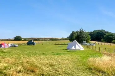Overview of Swift Farm Camping with grass pitches and a bell tent