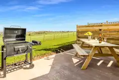Private picnic bench and BBQ on outdoor patio with countryside views