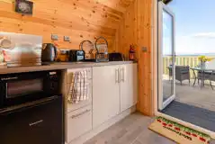 Kitchenette with hob, fridge, microwave, toaster, kettle, crockery and utensils