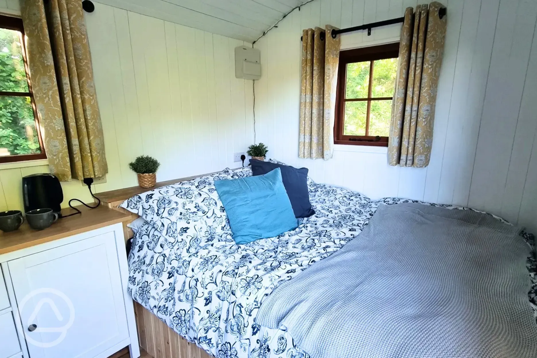 Shepherd's hut interior with a king size bed and bed linen