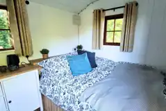 Shepherd's hut interior with a king size bed and bed linen