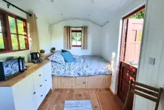 Shepherd's hut interior with a king size bed and bed linen