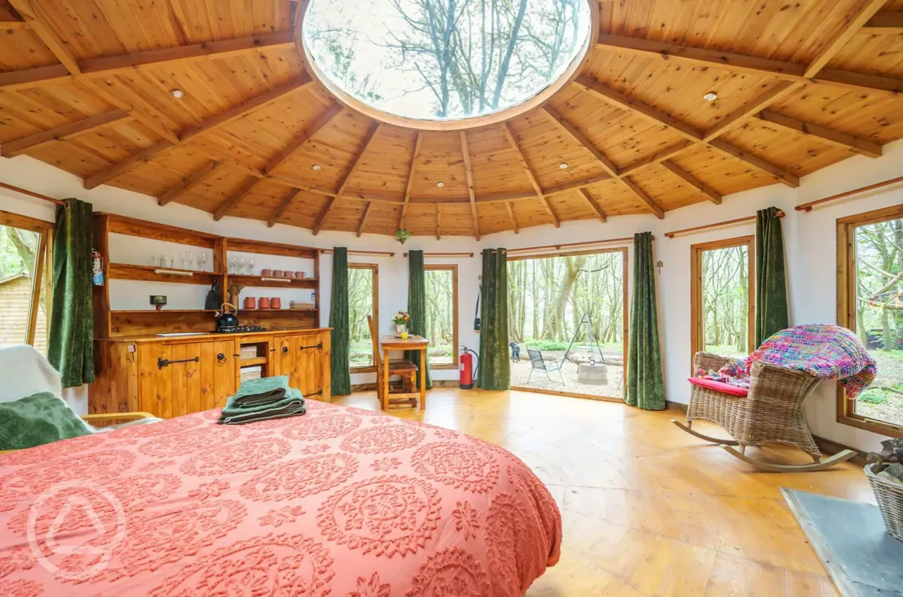Roundhouse wooden yurt interior with a king size bed