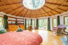 Roundhouse wooden yurt interior with a king size bed Roundhouse wooden yurt interior with a king size bed