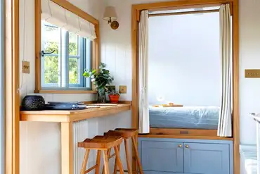 Saltmarsh shepherd's hut interior bedroom and dining bench