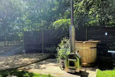 Private wood-fired hot tub and patio area with seating