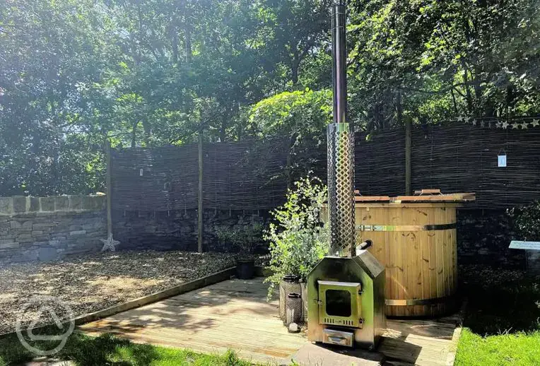 Private wood-fired hot tub and patio area with seating