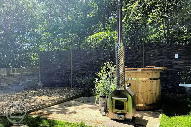 Private wood-fired hot tub and patio area with seating
