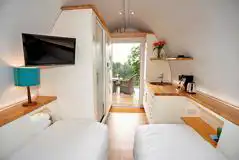 Standard ensuite pod interior with a double bed, twin beds (bedding), and TV Standard ensuite pod interior with a double bed, twin beds (bedding), and TV