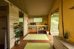 Safari tent kitchen area with a gas hob and crockery