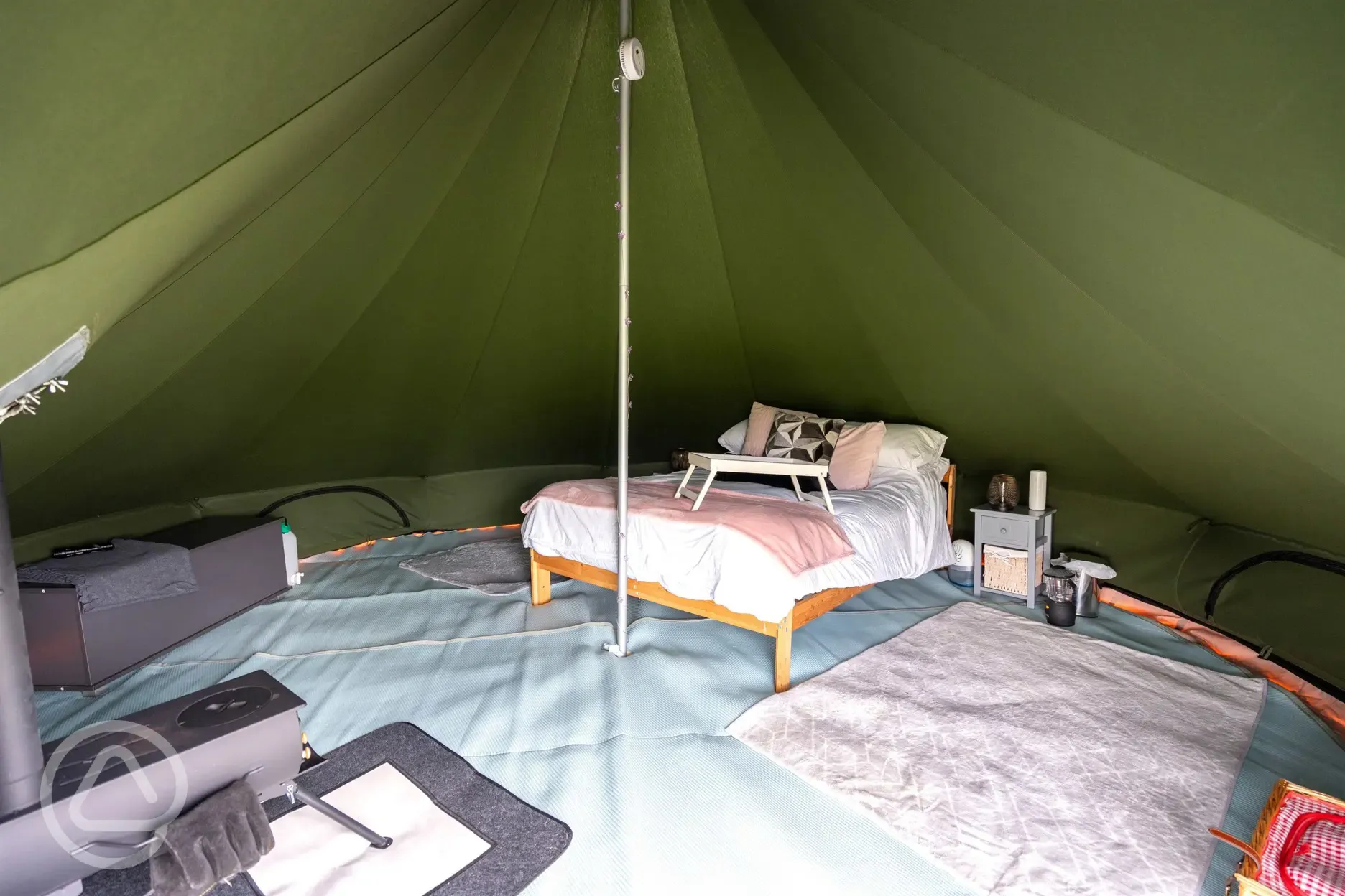 Bell tent double bed and furnishings at Oakwood Marina