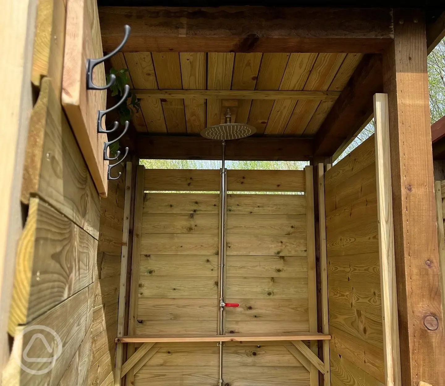 Shower shack interior with rainfall shower and hooks
