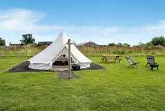Furnished bell tents with a private fire pit, solar lights, and picnic bench