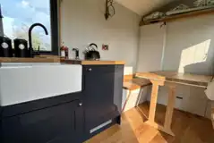 Kitchenette in shepherd's hut with a kettle, fridge, and cooking space