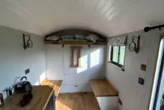 Double bed folded up for storage area and seating in shepherd's hut