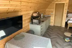 Ensuite glamping pod kitchenette, dining area, and TV