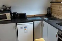 The Heron's Nest - kitchen area with a fridge, kettle, and microwave