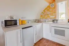 The Bee Hive kitchen with a microwave, fridge, kettle, and cutlery