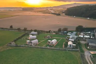 Aerial of The Galloway Steading at sunset, facing inland