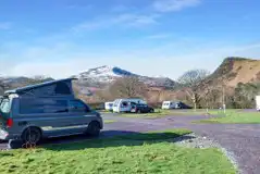 Electric hardstanding and grass pitches at Cae Du overlooking Snowdonia (Eryri)
