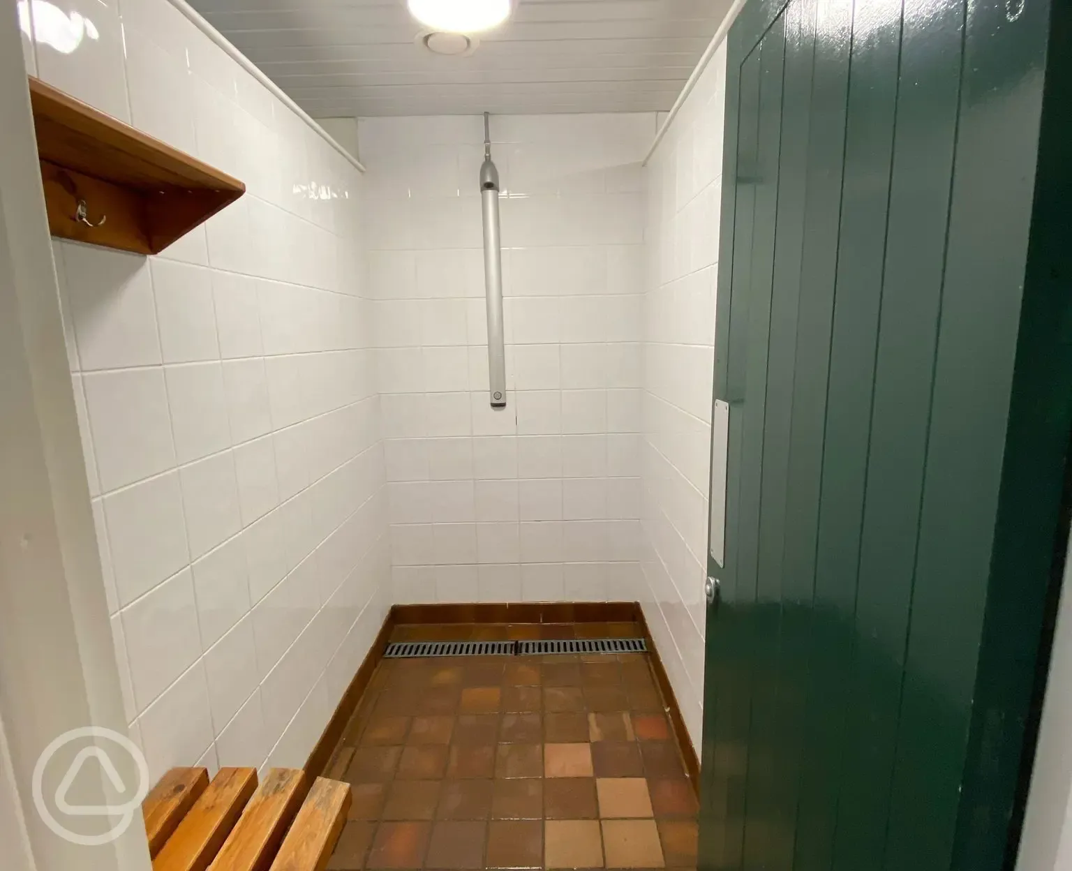 Campsite private shower cubicles with a clothing hook and bench