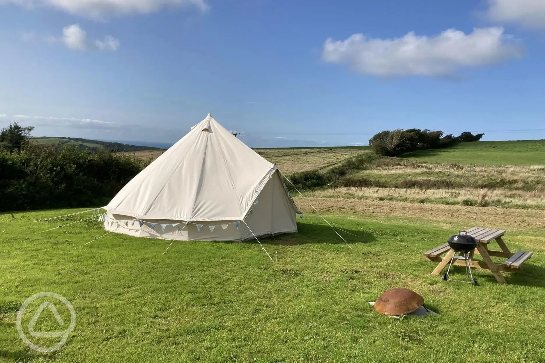 Bell tent with a picnic bench and BBQ at Giddy Farm