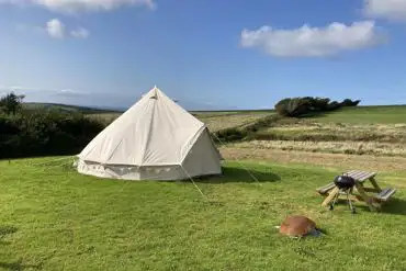 Bell tent with a picnic bench and BBQ at Giddy Farm