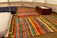 Bell tent interior furnished with airbeds, futons, and rugs Bell tent interior furnished with airbeds, futons, and rugs