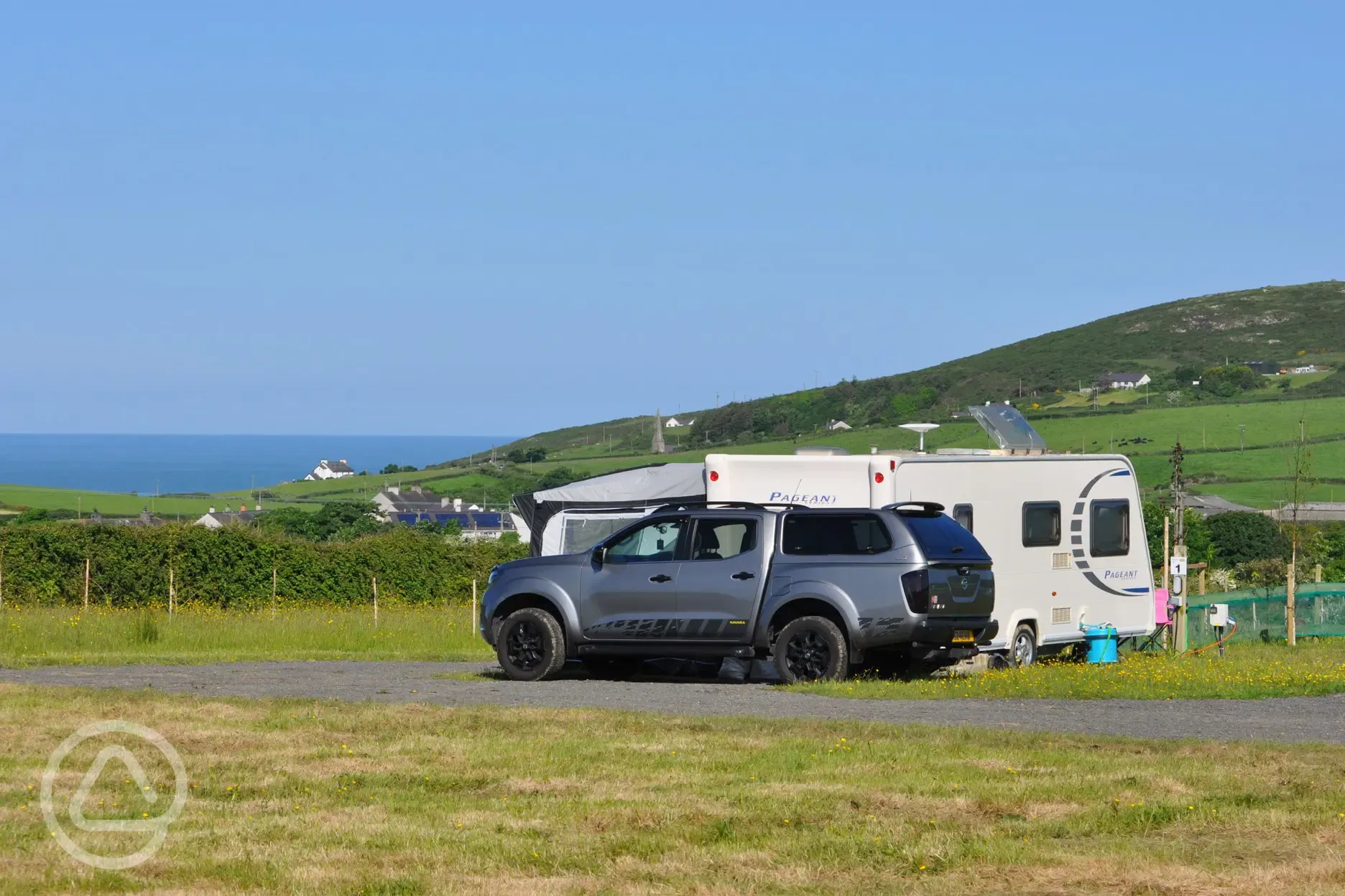 Grass and hardstanding touring pitches with optional electric and sea views