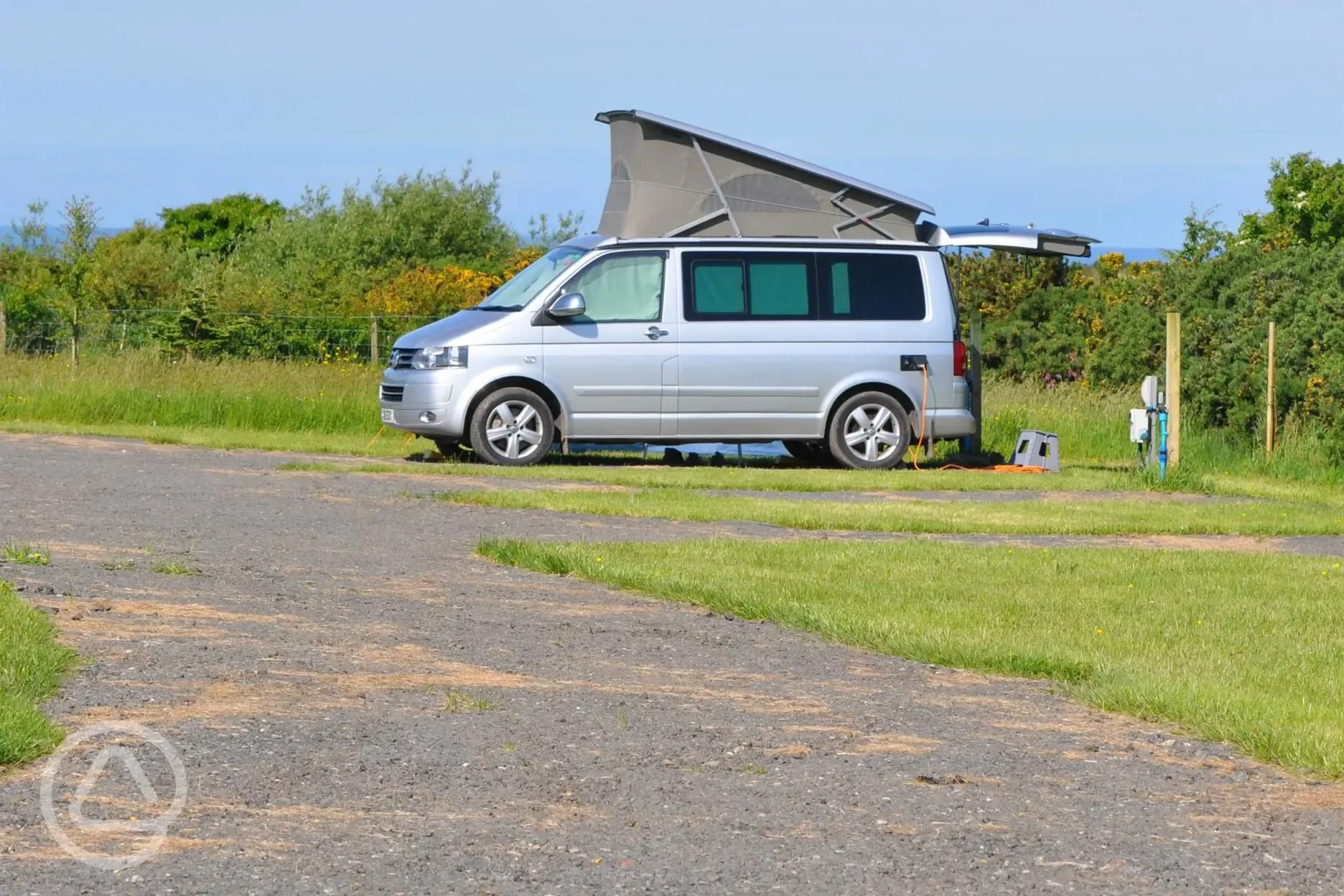 Roof tent on a grass and hardstanding touring pitch with optional electric