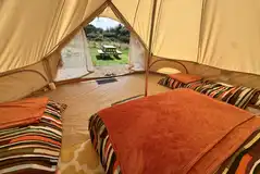 Standard furnished bell tent with a king bed and two single air beds