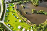 Aerial of Tregonetha Lake with camping pitches by the water