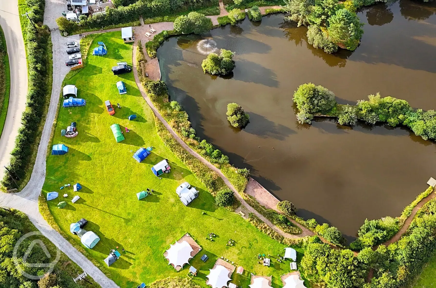 Bird's eye view of Tregonetha Lake with camping pitches by the water Bird's eye view of Tregonetha Lake with camping pitches by the water