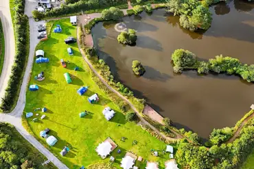 Bird's eye view of Tregonetha Lake with camping pitches by the water